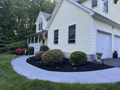 A cut mulch bed edge curving around the front of a house